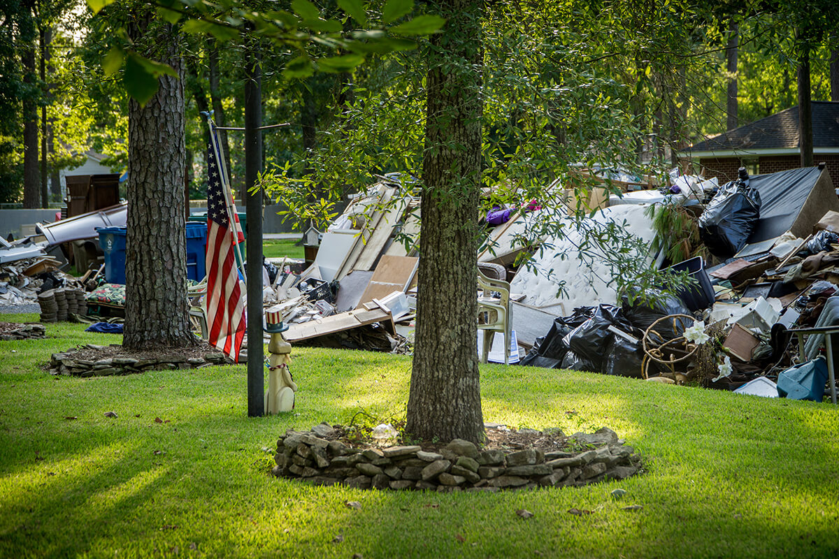 American Flag next to a devastated home's trash pile